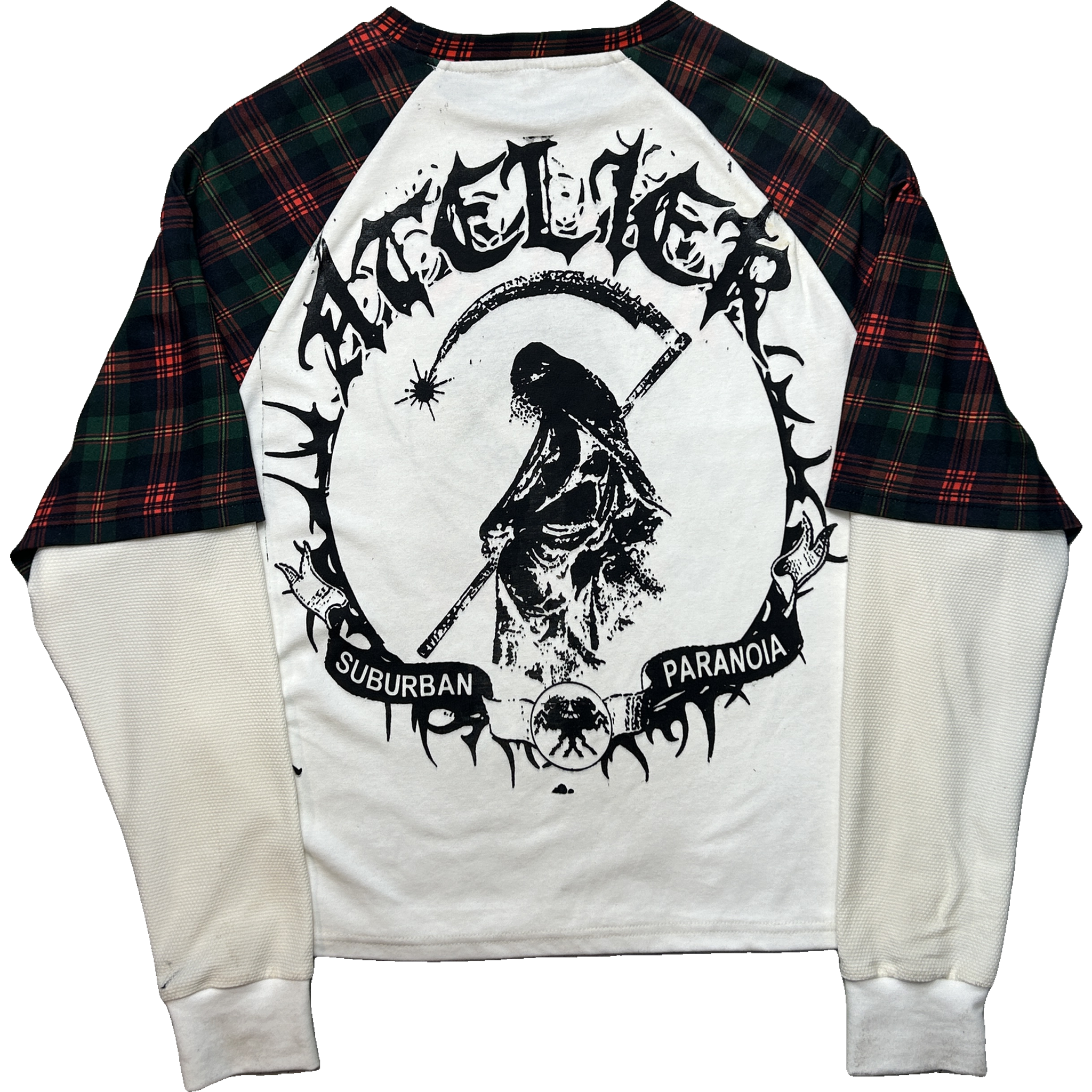 A raglan-style long-sleeve shirt laid flat on a white background, featuring an off-white body and sleeves, dark red and green plaid sleeves, and a large black graphic print on the front with the text 'SUBURBAN PARANOIA' and a grim reaper design.