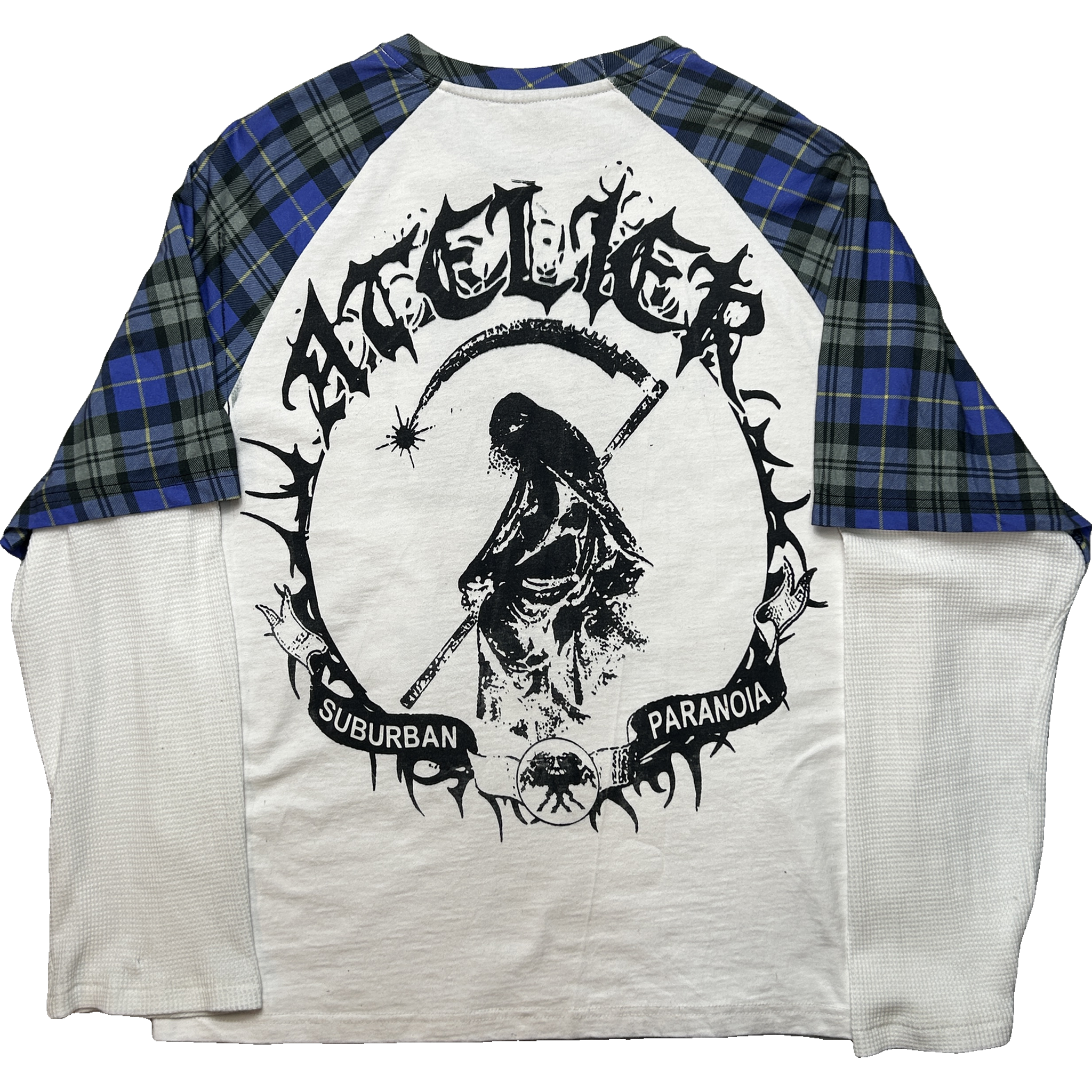 A raglan-style long-sleeve shirt laid flat on a white background, featuring a white body and blue/black plaid sleeves. The front has a large black graphic of a skull with a scythe inside a circular frame, with the words 'Paranoid Suburban' and stylized text across the shoulders.